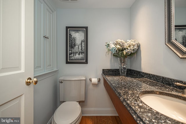 bathroom with vanity, toilet, and hardwood / wood-style floors