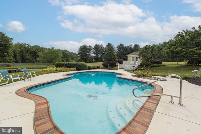 view of pool featuring a yard, a patio area, and an outdoor structure