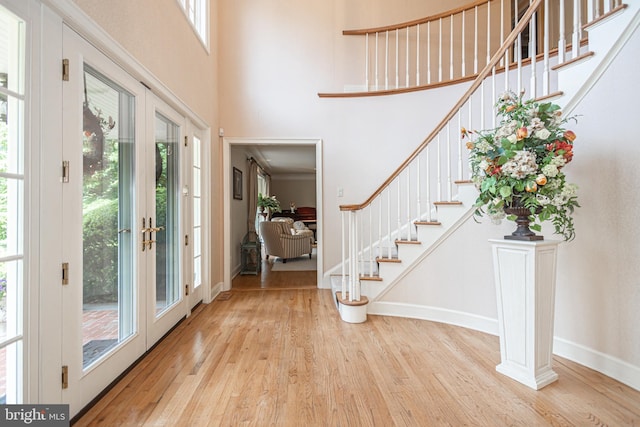 foyer with french doors, a wealth of natural light, and light hardwood / wood-style flooring