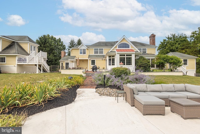 view of front facade with an outdoor living space, an outdoor structure, a front lawn, and a patio