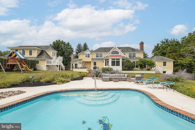 view of pool featuring a yard, outdoor lounge area, a playground, and a patio