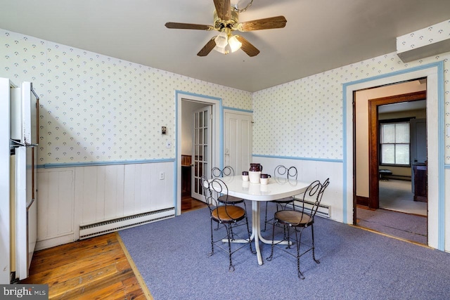 dining area with a baseboard radiator, ceiling fan, and dark hardwood / wood-style flooring