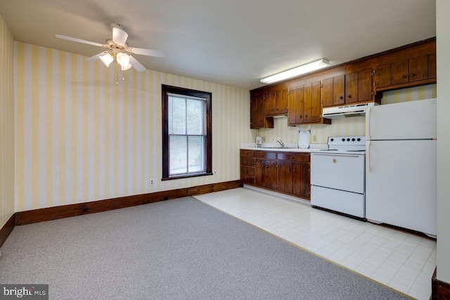 kitchen featuring sink, white appliances, and light colored carpet