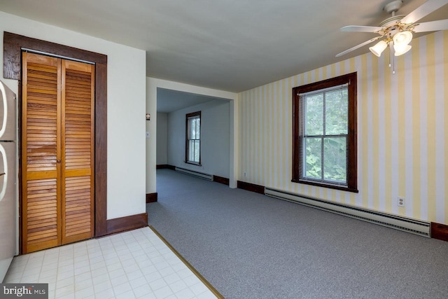 unfurnished room with baseboard heating and light colored carpet