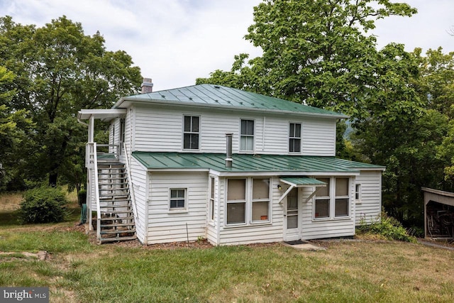 rear view of house featuring a yard