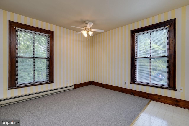 empty room with ceiling fan, a healthy amount of sunlight, and baseboard heating