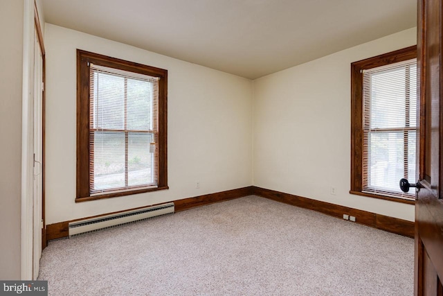 carpeted spare room featuring a baseboard radiator and a healthy amount of sunlight