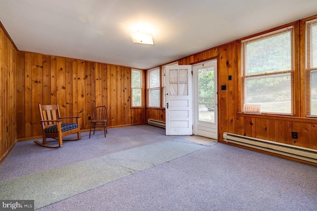 carpeted entryway featuring a baseboard heating unit and wooden walls