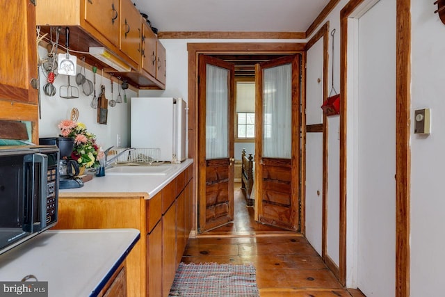 kitchen featuring sink, white fridge, and light hardwood / wood-style flooring