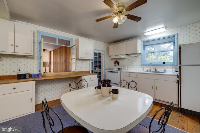 kitchen featuring white cabinetry, dark hardwood / wood-style floors, sink, and white appliances