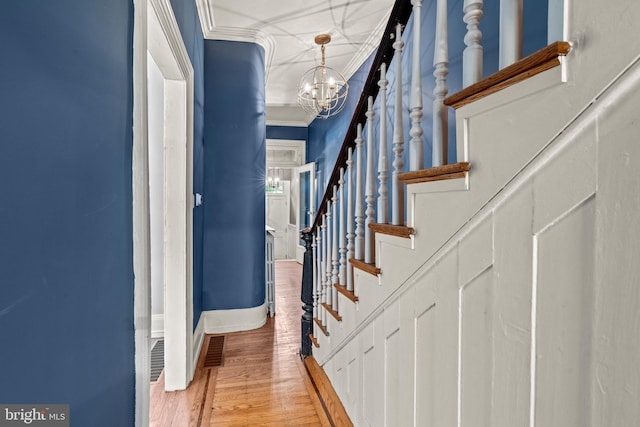 interior space with light wood-type flooring, ornamental molding, and a chandelier