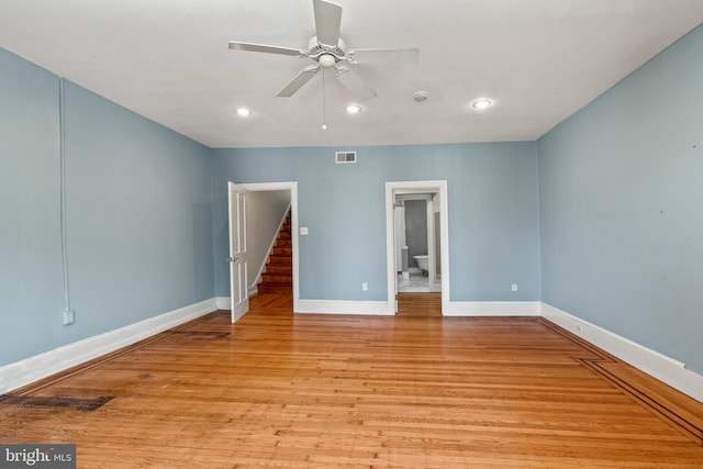 unfurnished bedroom with ceiling fan, ensuite bathroom, and light hardwood / wood-style flooring