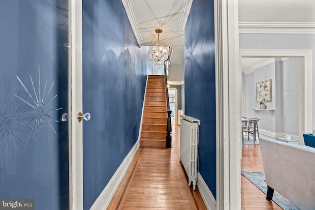 corridor featuring crown molding, a chandelier, and wood-type flooring