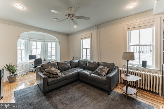 living room with ceiling fan, crown molding, plenty of natural light, and radiator