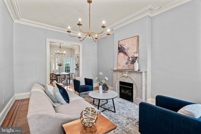 living room featuring an inviting chandelier, ornamental molding, and a fireplace