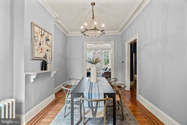 dining space with a notable chandelier, hardwood / wood-style floors, and ornamental molding