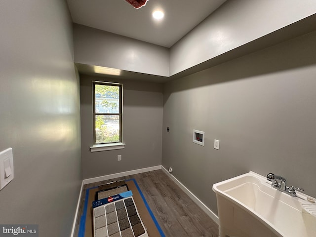 washroom featuring dark wood-type flooring, sink, washer hookup, and hookup for an electric dryer