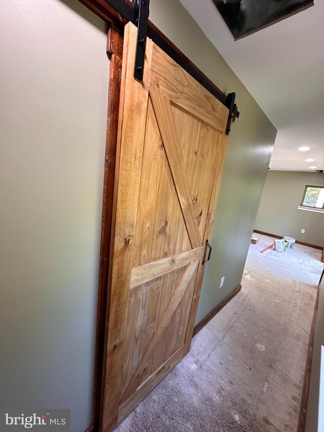 interior details featuring a barn door and carpet