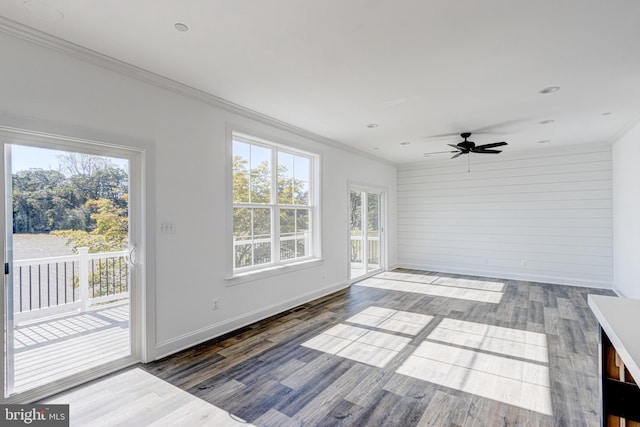 empty room with crown molding, wood-type flooring, and ceiling fan