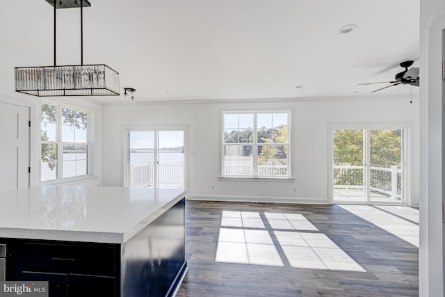 kitchen with crown molding, hanging light fixtures, dark hardwood / wood-style flooring, a kitchen island, and ceiling fan