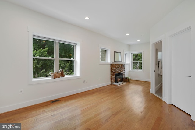 unfurnished living room featuring a fireplace and light hardwood / wood-style flooring