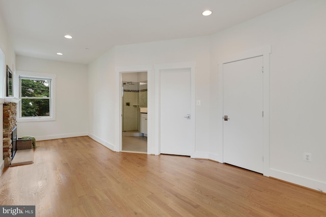 unfurnished bedroom with connected bathroom and light hardwood / wood-style flooring