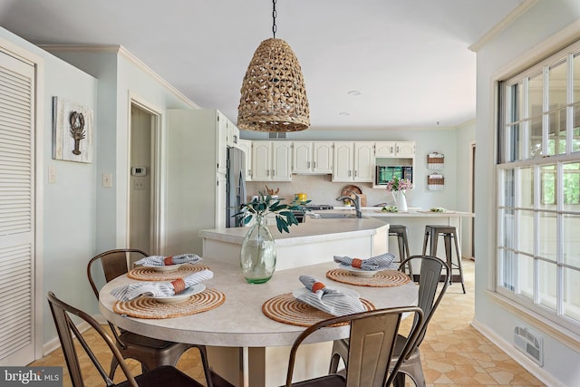 dining room with sink and crown molding