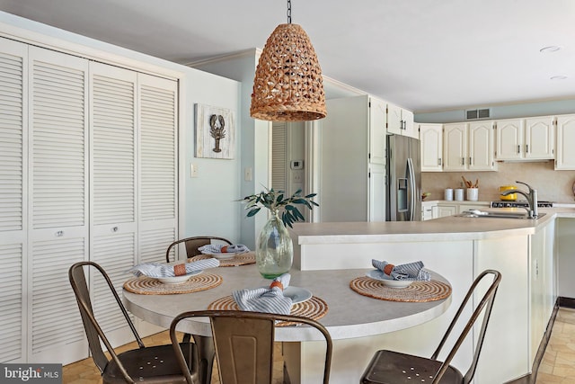 dining space featuring sink and crown molding