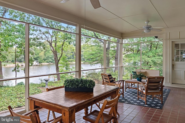 sunroom featuring a water view, ceiling fan, and a wealth of natural light