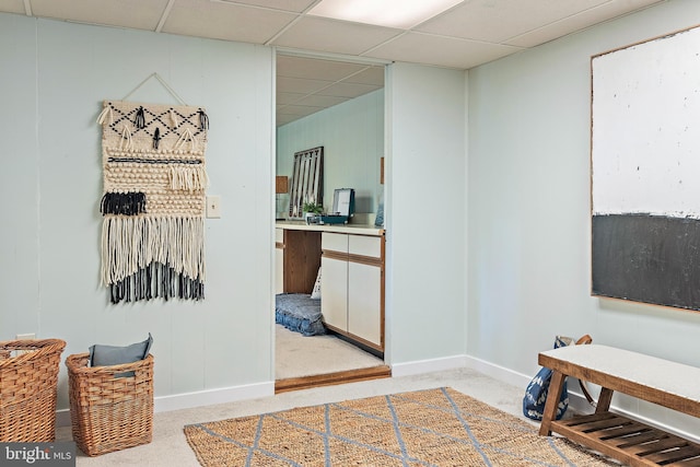 interior space featuring a drop ceiling and carpet flooring