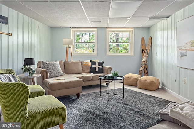 carpeted living room with a paneled ceiling