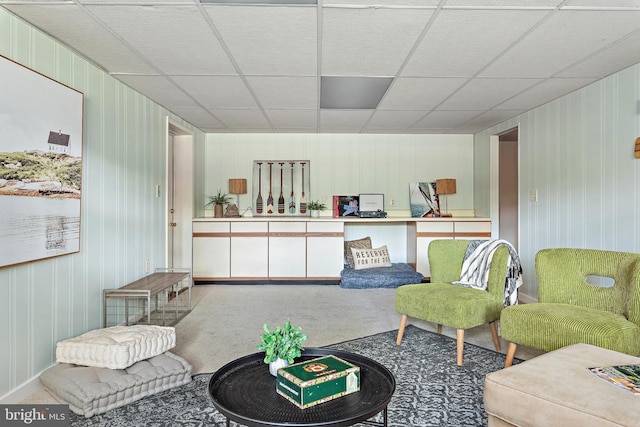 sitting room featuring carpet and a drop ceiling