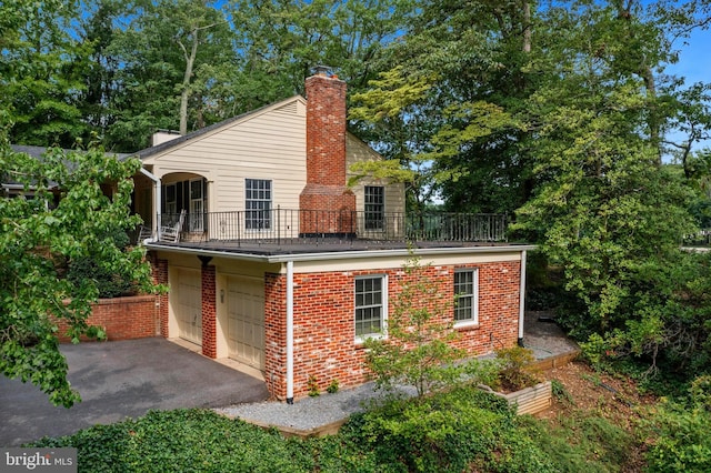 view of side of property featuring a balcony and a garage