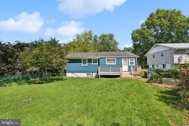 back of house with a deck and a lawn