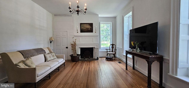 living room featuring an inviting chandelier and hardwood / wood-style floors