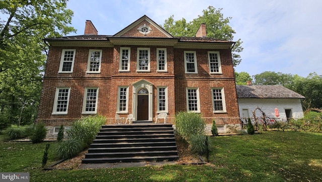 colonial home with a front lawn