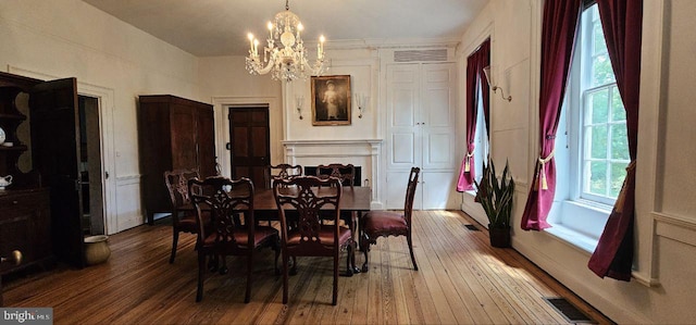 dining room with crown molding, an inviting chandelier, and hardwood / wood-style flooring