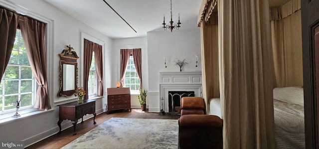 living area with an inviting chandelier, dark hardwood / wood-style flooring, and a wealth of natural light