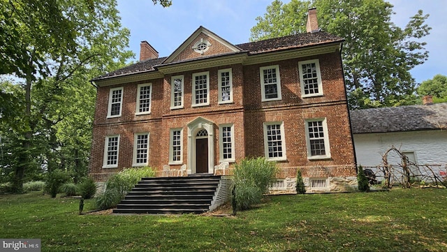 colonial home featuring a front lawn