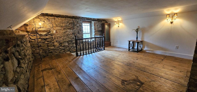 bonus room with lofted ceiling, a textured ceiling, and hardwood / wood-style flooring