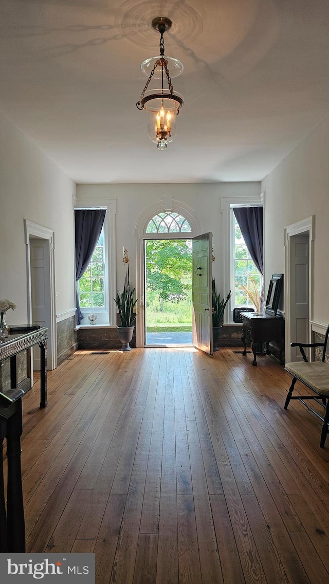 interior space with hardwood / wood-style floors and an inviting chandelier