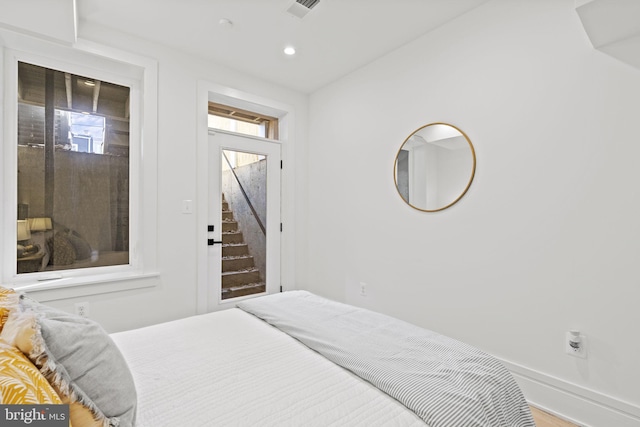 bedroom featuring hardwood / wood-style flooring and access to outside