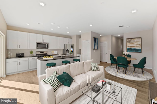 living room featuring sink and light hardwood / wood-style floors