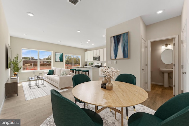 dining area featuring sink and light wood-type flooring