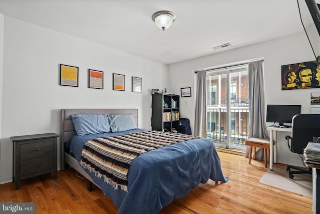 bedroom with wood-type flooring and access to outside