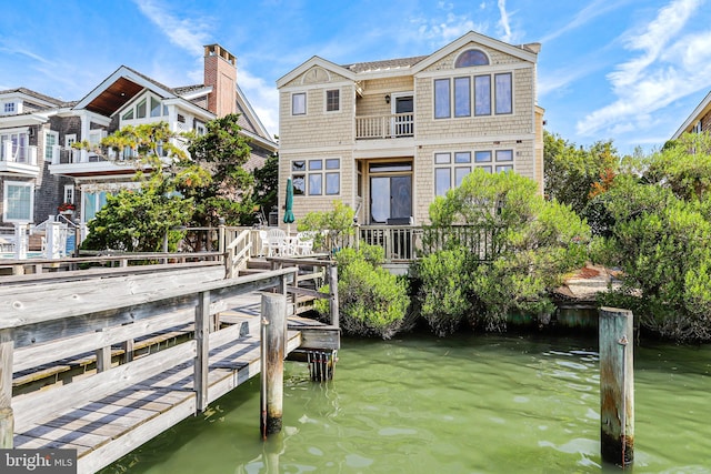 dock area with a balcony and a water view