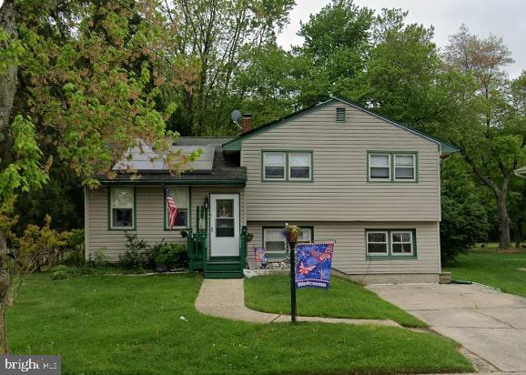 tri-level home with a front lawn