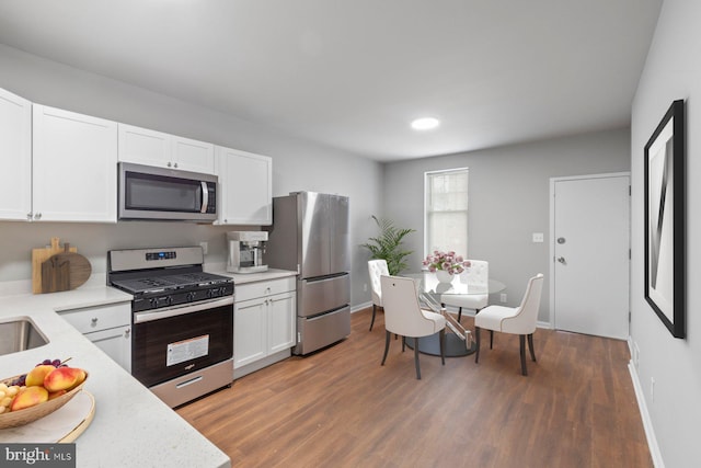 kitchen featuring white cabinets, stainless steel appliances, and wood-type flooring