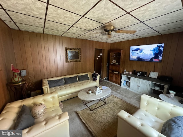 living room with ceiling fan and wooden walls