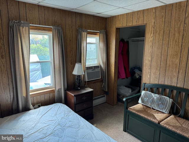 bedroom with cooling unit, a baseboard radiator, a drop ceiling, and carpet flooring